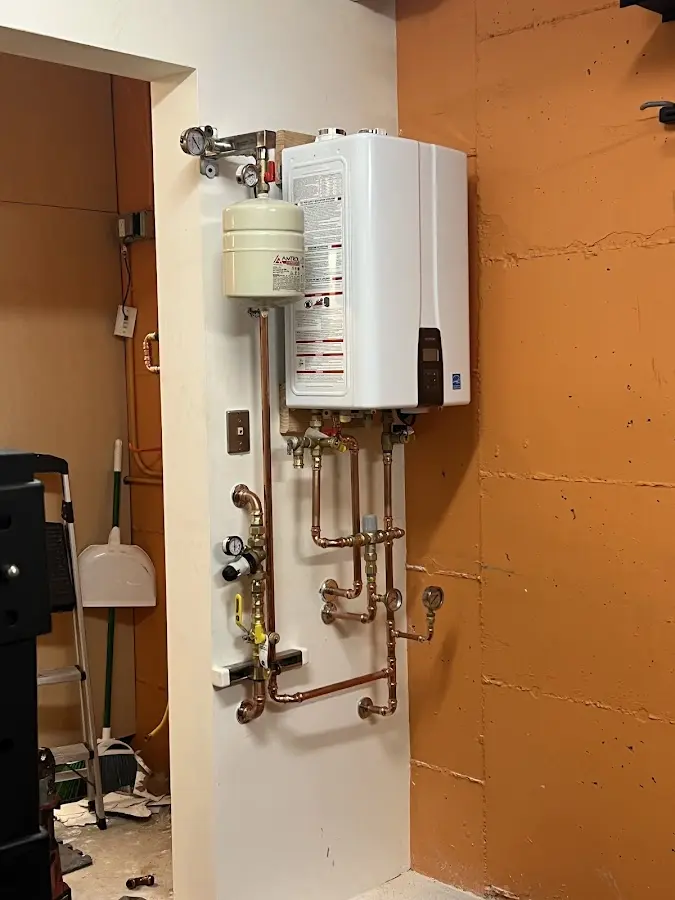 Plumbing technician inspecting water heater connections in Brookings